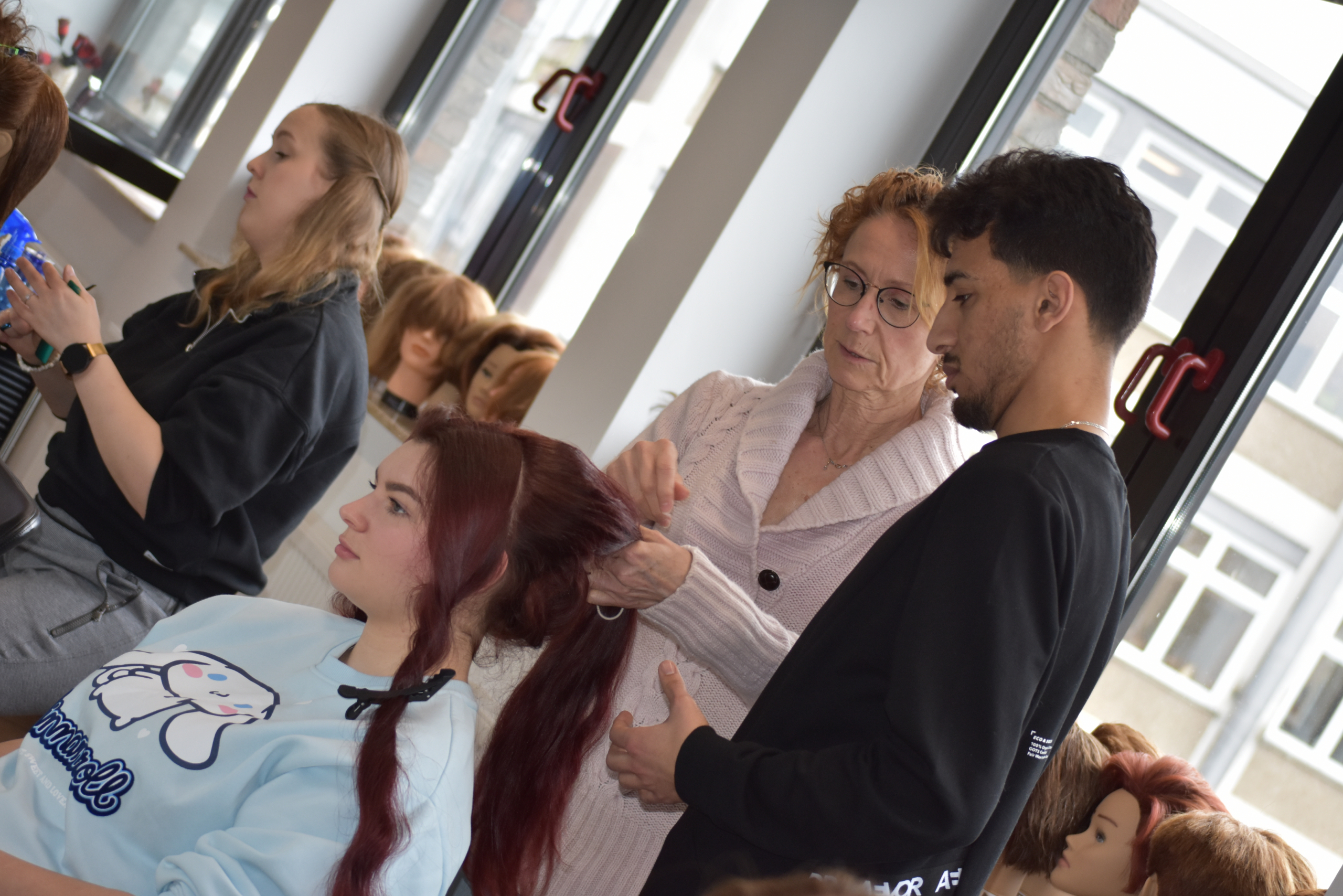 Abbildung einer unterweisung im Friseurhandwerk zum Thema Hochsteckfrisuren
